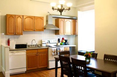 kitchen inside drayton house with stove, sink, dishwasher, cabinets and countertop, and kitchen table