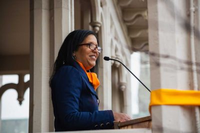 Gail Fortes speaking and smiling at podium at ribbon cutting for Drayton House