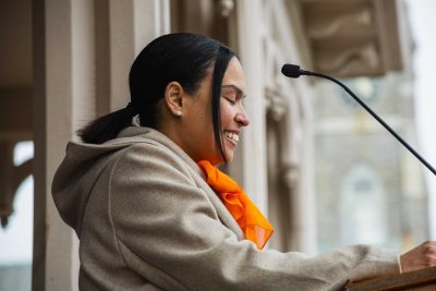 Lindsay Carter-Monteiro speaking and smiling at podium at ribbon cutting for Drayton House