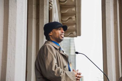 Joe Drayton speaking and smiling at podium at ribbon cutting for Drayton House