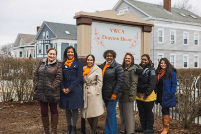 YWCASEMA board and staff standing in front of Drayton House sign outdoors